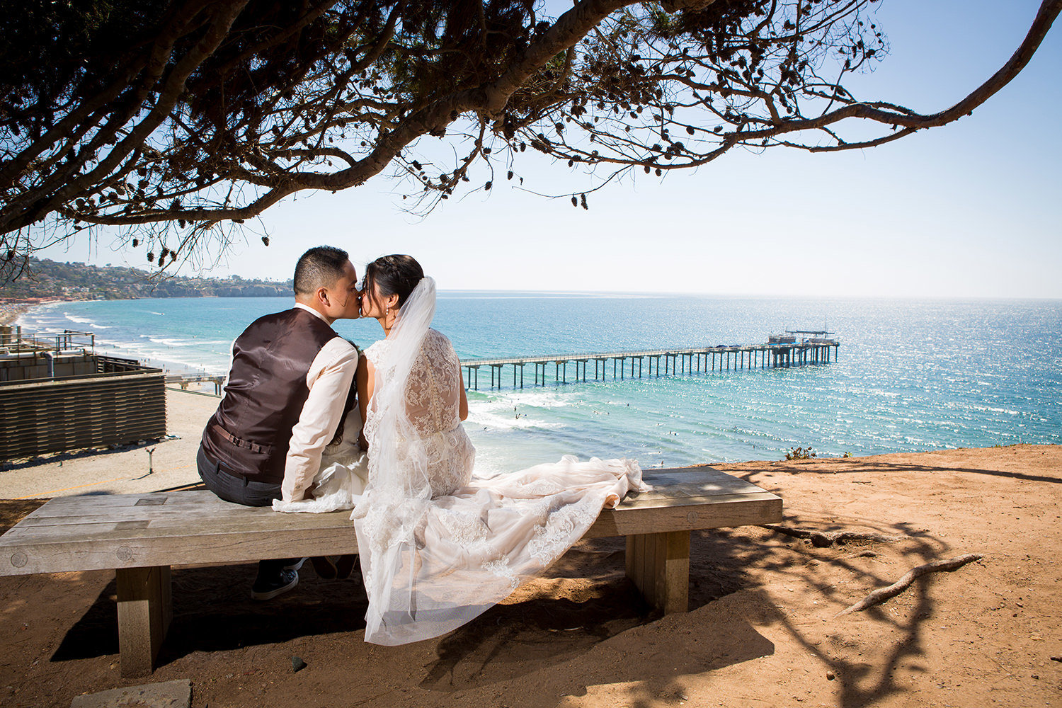couple kissing at martin johnson house with ocean in background