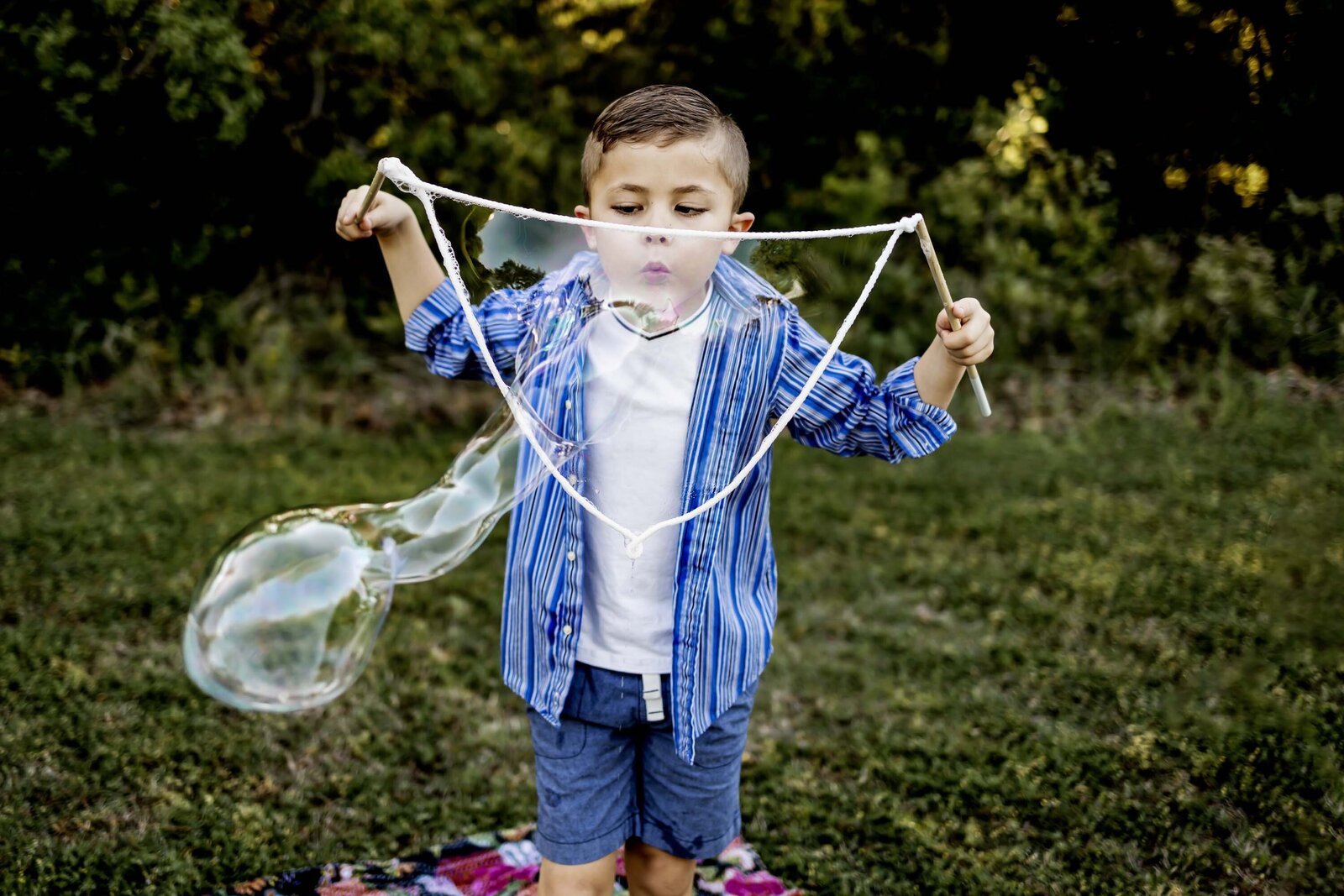 young boy from southlake texas plays with giant bubbles