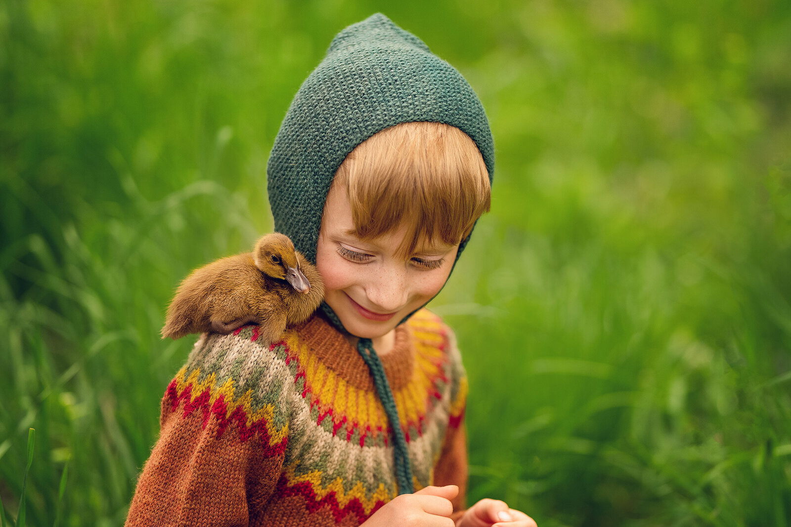 7-year-old Nicholas sits in an Oconomowoc field with a baby duckling on his shoulder.