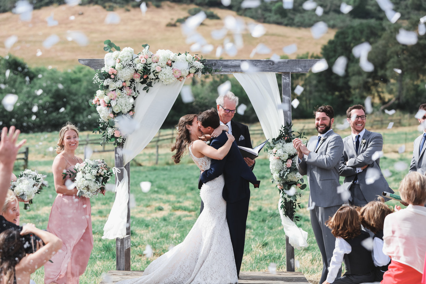 Bride and groom at wedding ceremony, flowing flower petals at bay area wedding