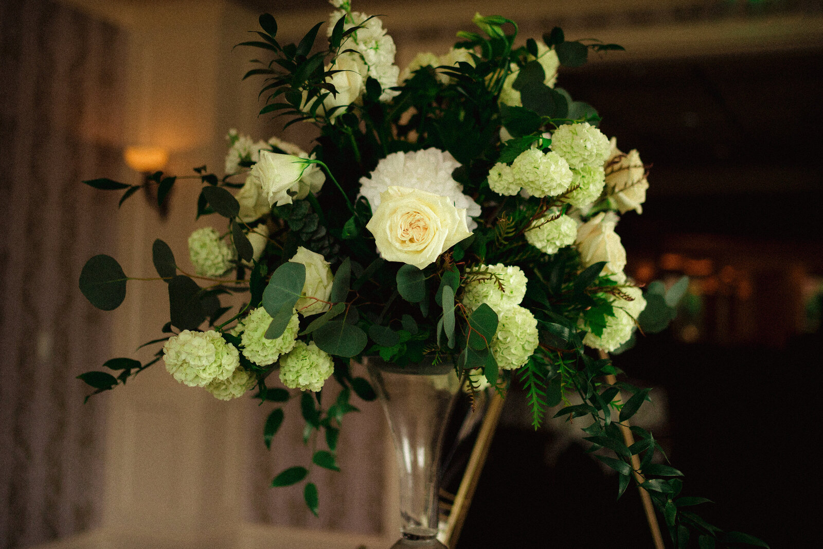 fresh greenery compliments large white peonies and roses in table top arrangement