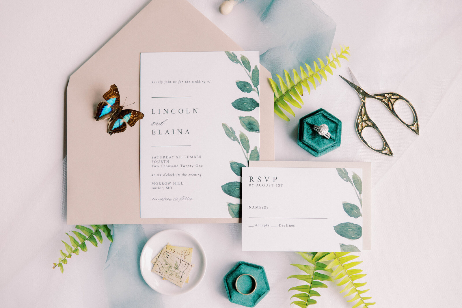 Simple wedding invitation flay lay with butterfly and ring detail