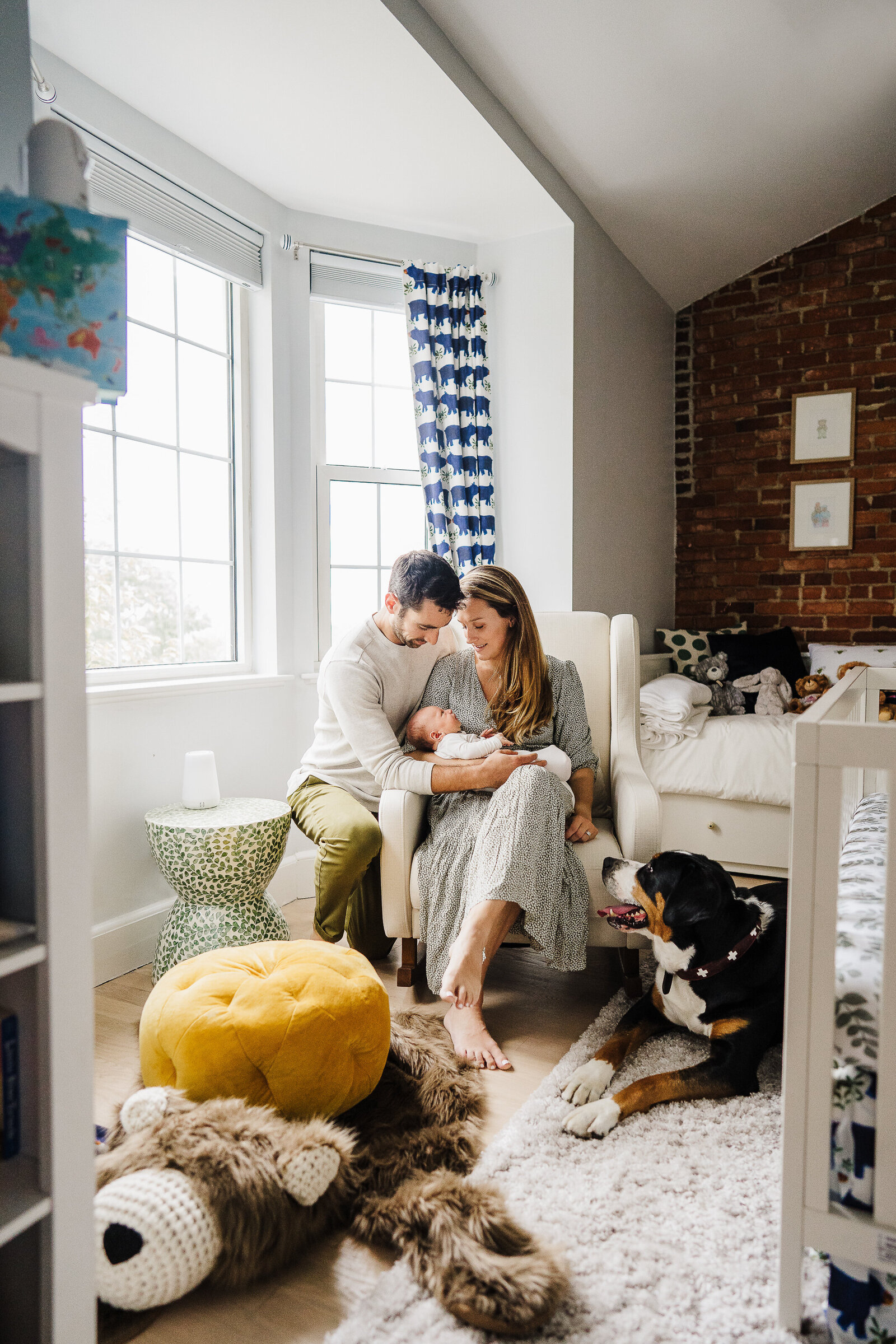 family with new baby sits in styled apartment nursery in boston
