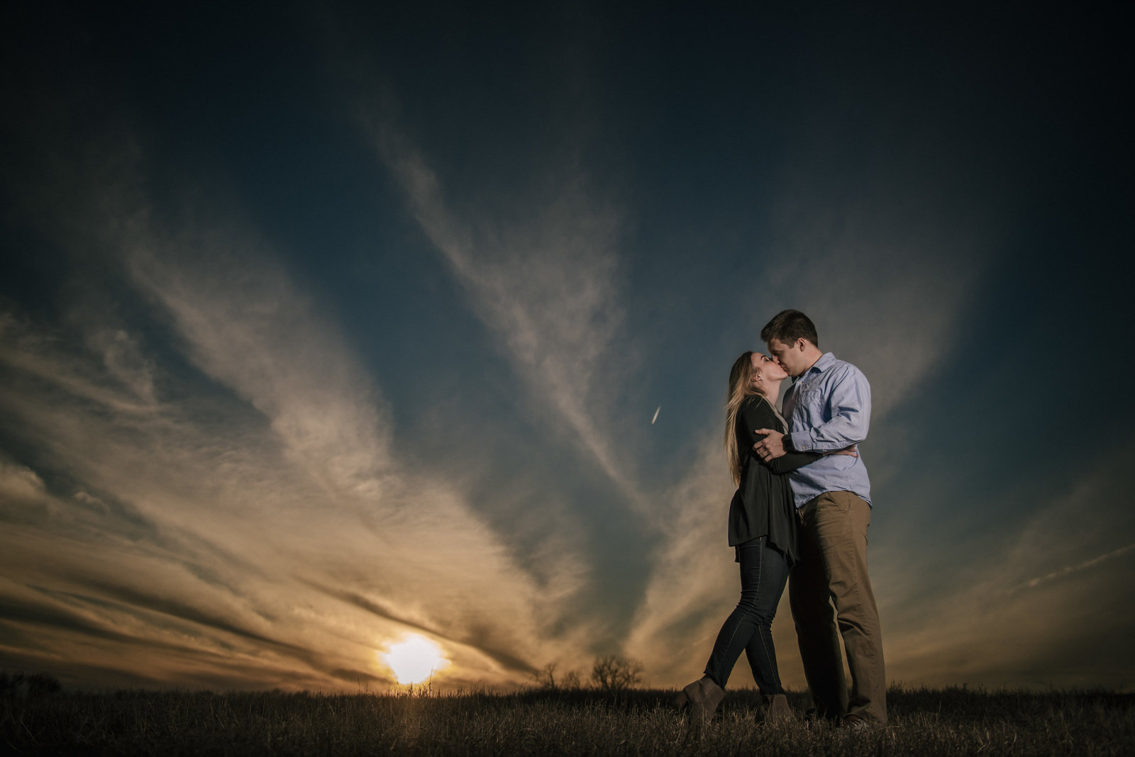 couple kissing at sunset strobist shot