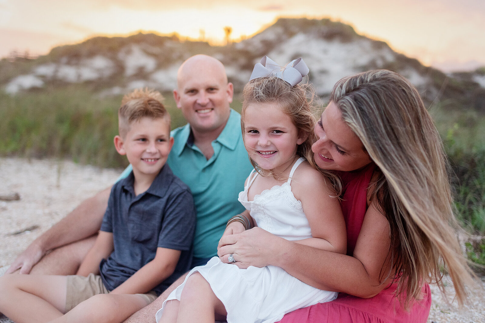 Family dressed in pinks and blues snuggled on Guana Reserve Beach in Ponte Vedra, FL.