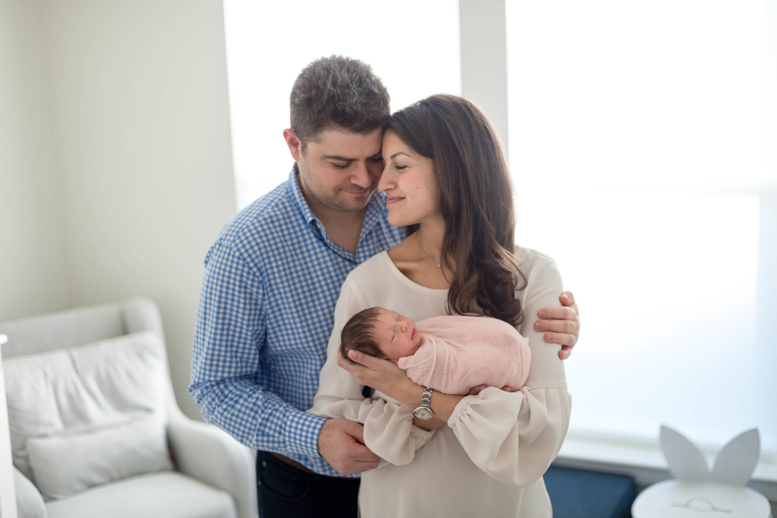 parents hugging newborn at home lifestyle session