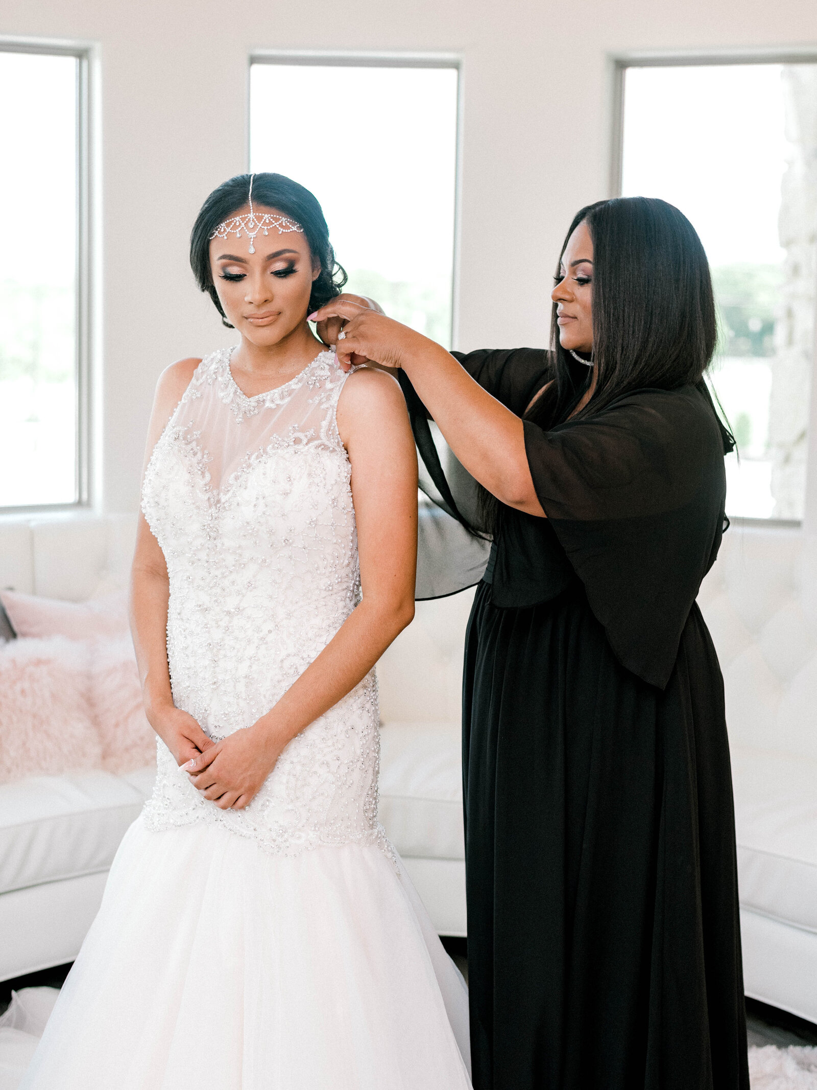 Bride with diamond headpiece and mermaid silhouette wedding dress getting ready with the mother of the bride