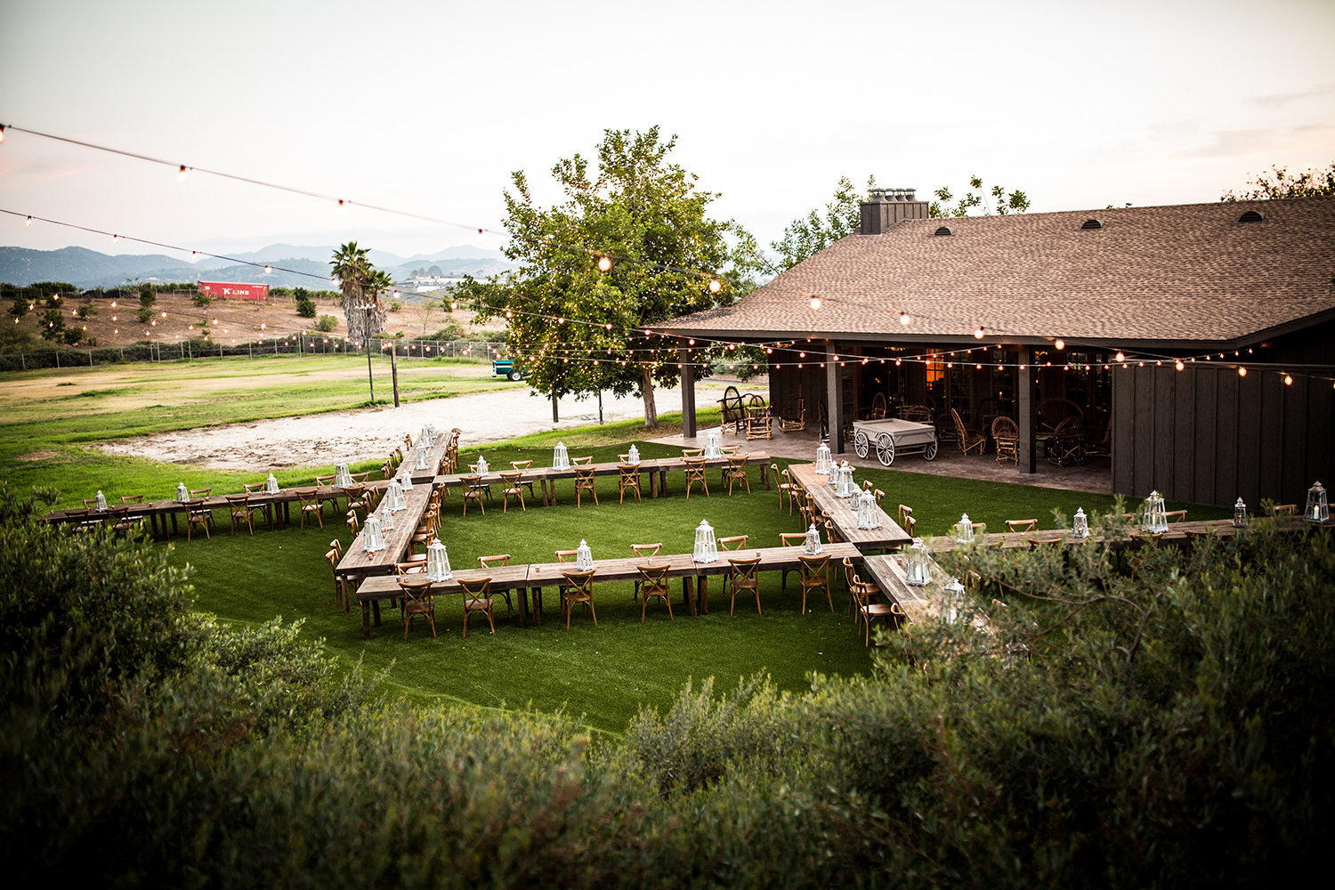 outside reception space with barn tables and rustic barn