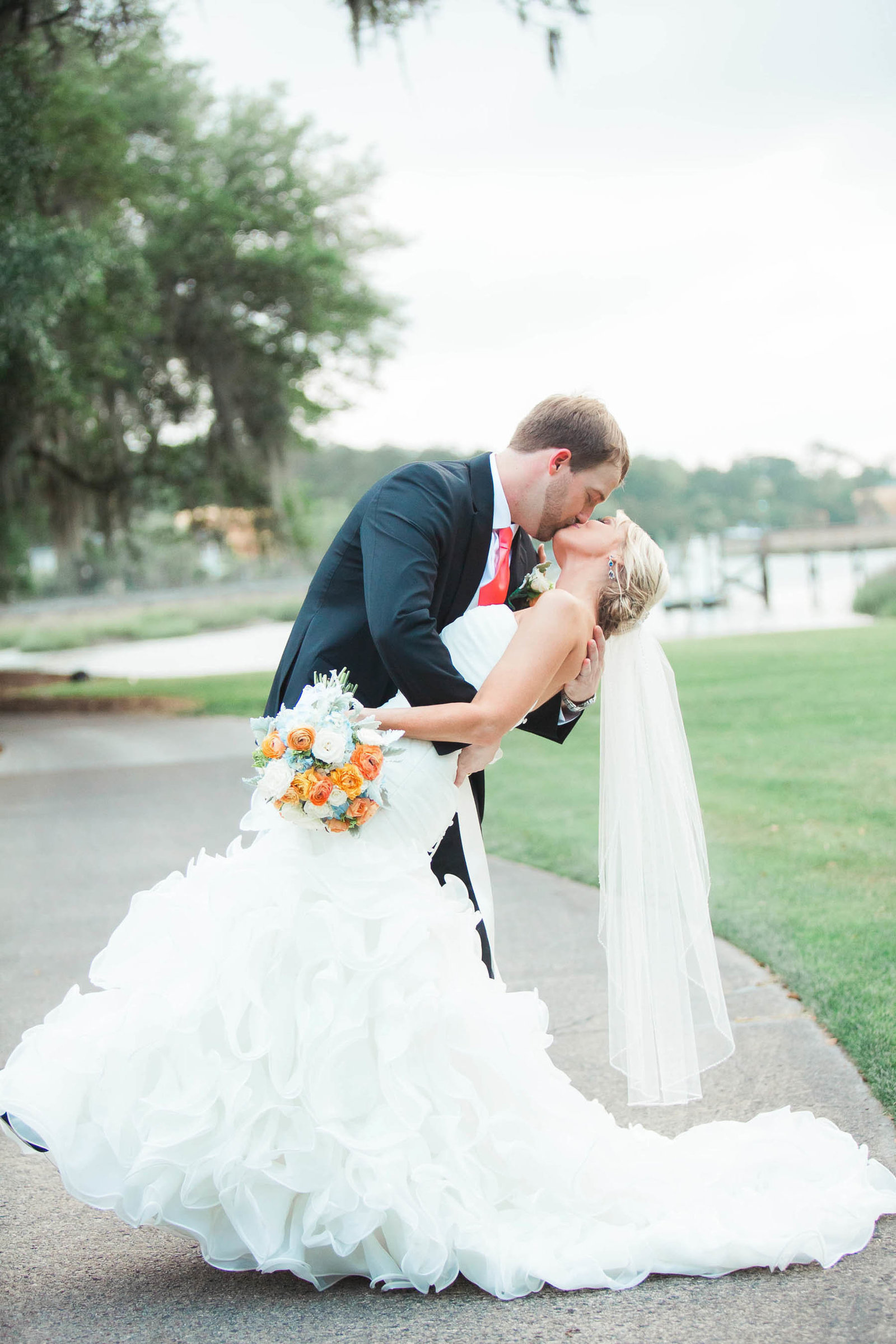 Bride and groom kiss in field, Dunes West Golf and River Club, Mt Pleasant, South Carolina