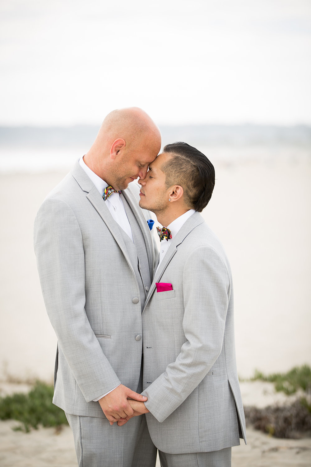Grooms share a sweet moment at beach in Coronado