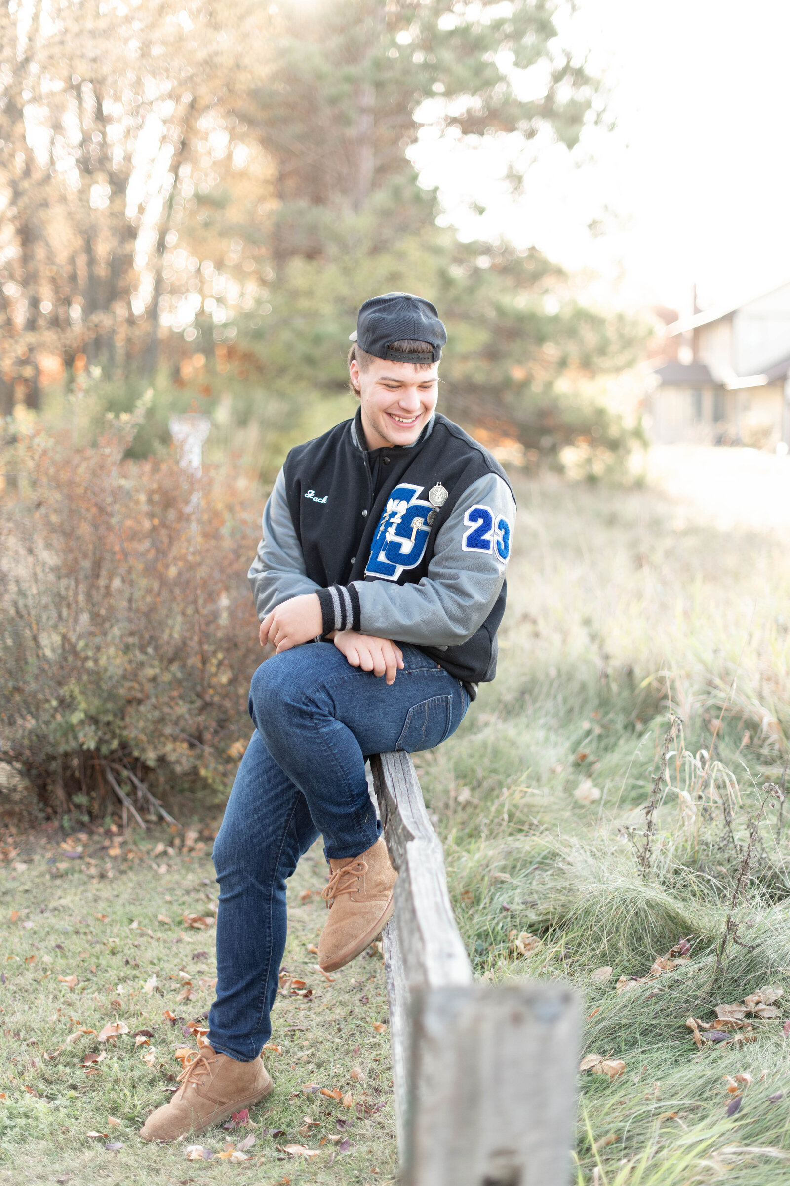 senior boy in lettermans jacket outside