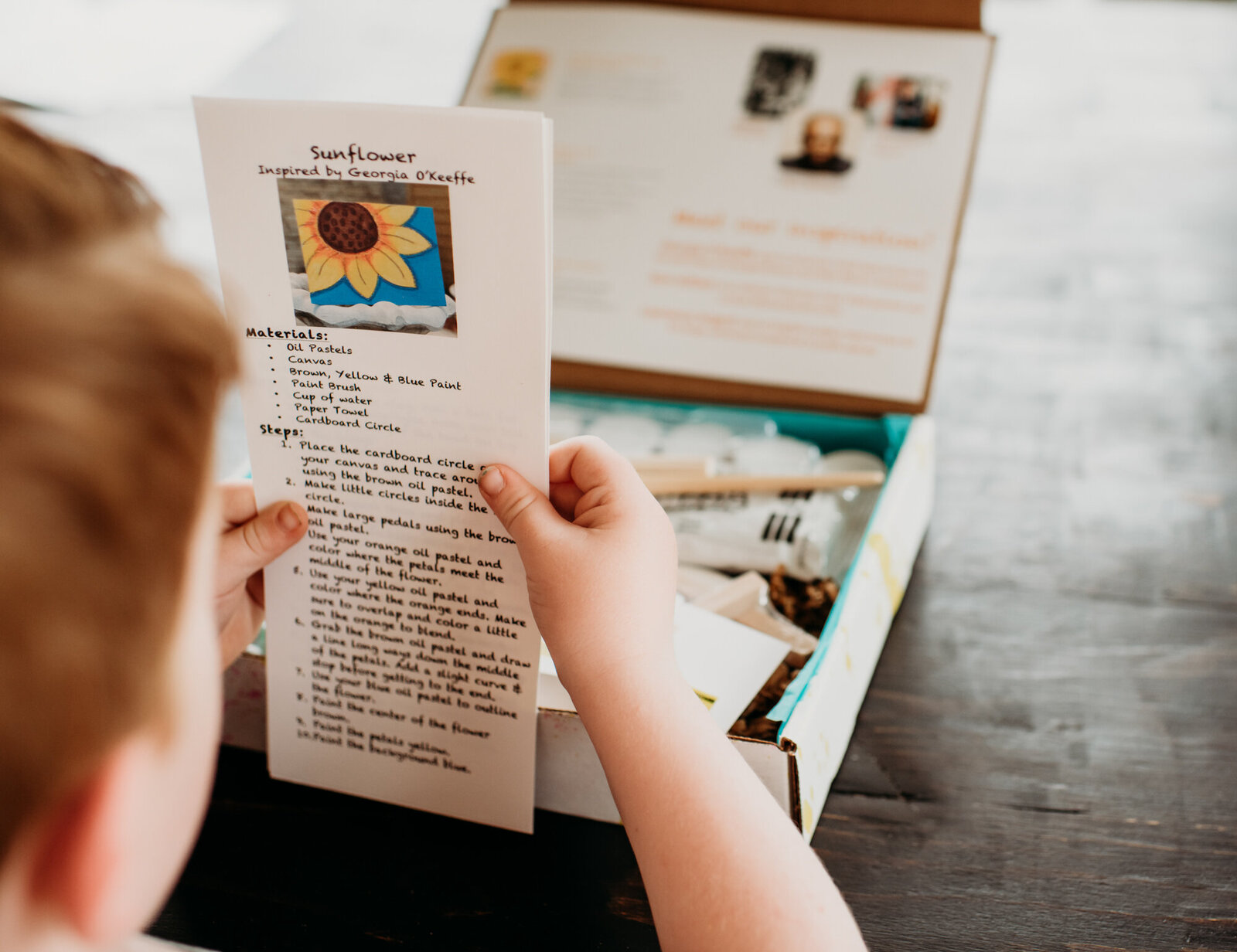 Branding Photographer, a child reviews instructions for a craft project from a craft box