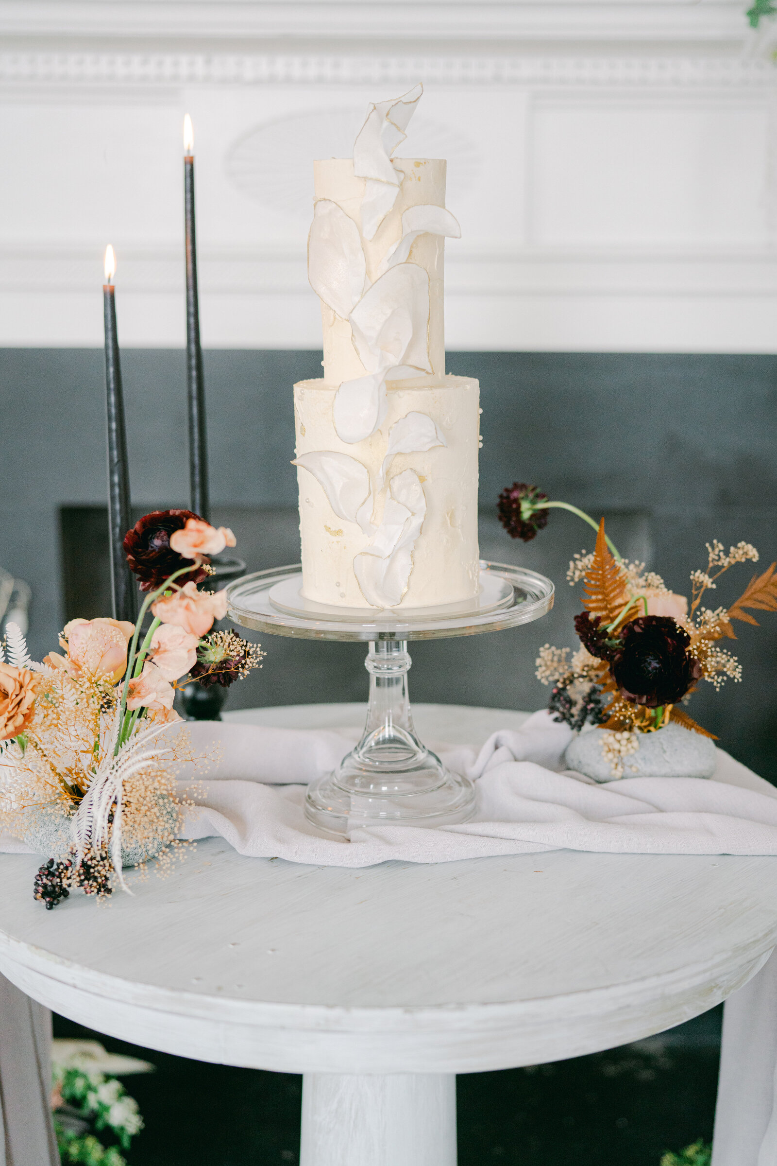 white wedding cake with flowers around it