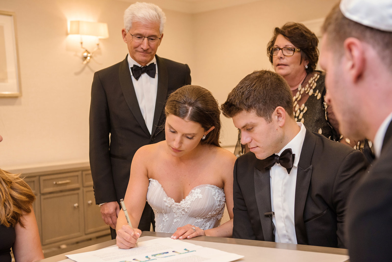 bride signing the ketubah at Glen Head Country Club