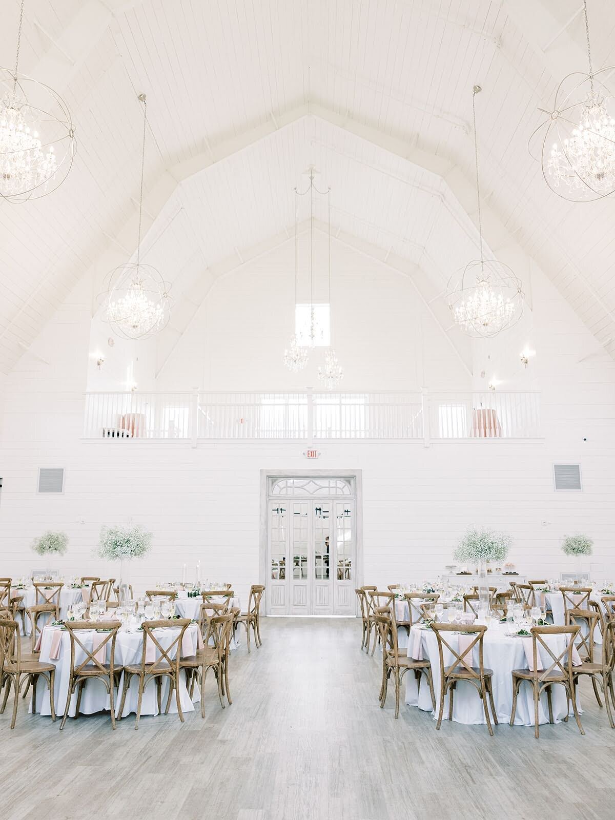 Pristine white barn wedding venue set up for wedding reception