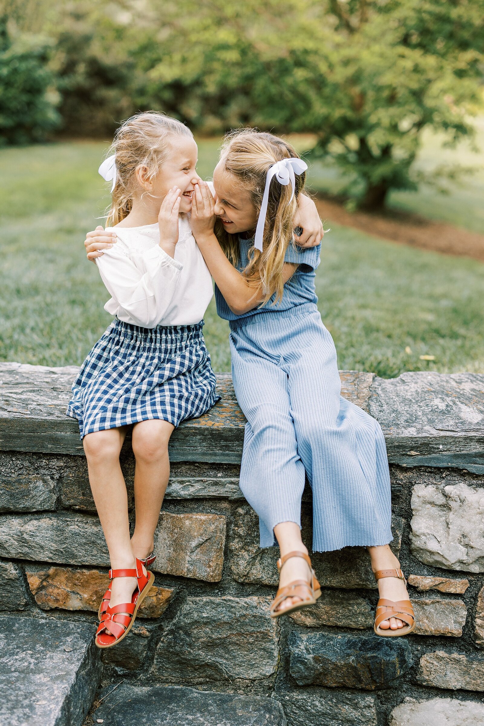sisters whispering secrets by Philadelphia Family Photographer