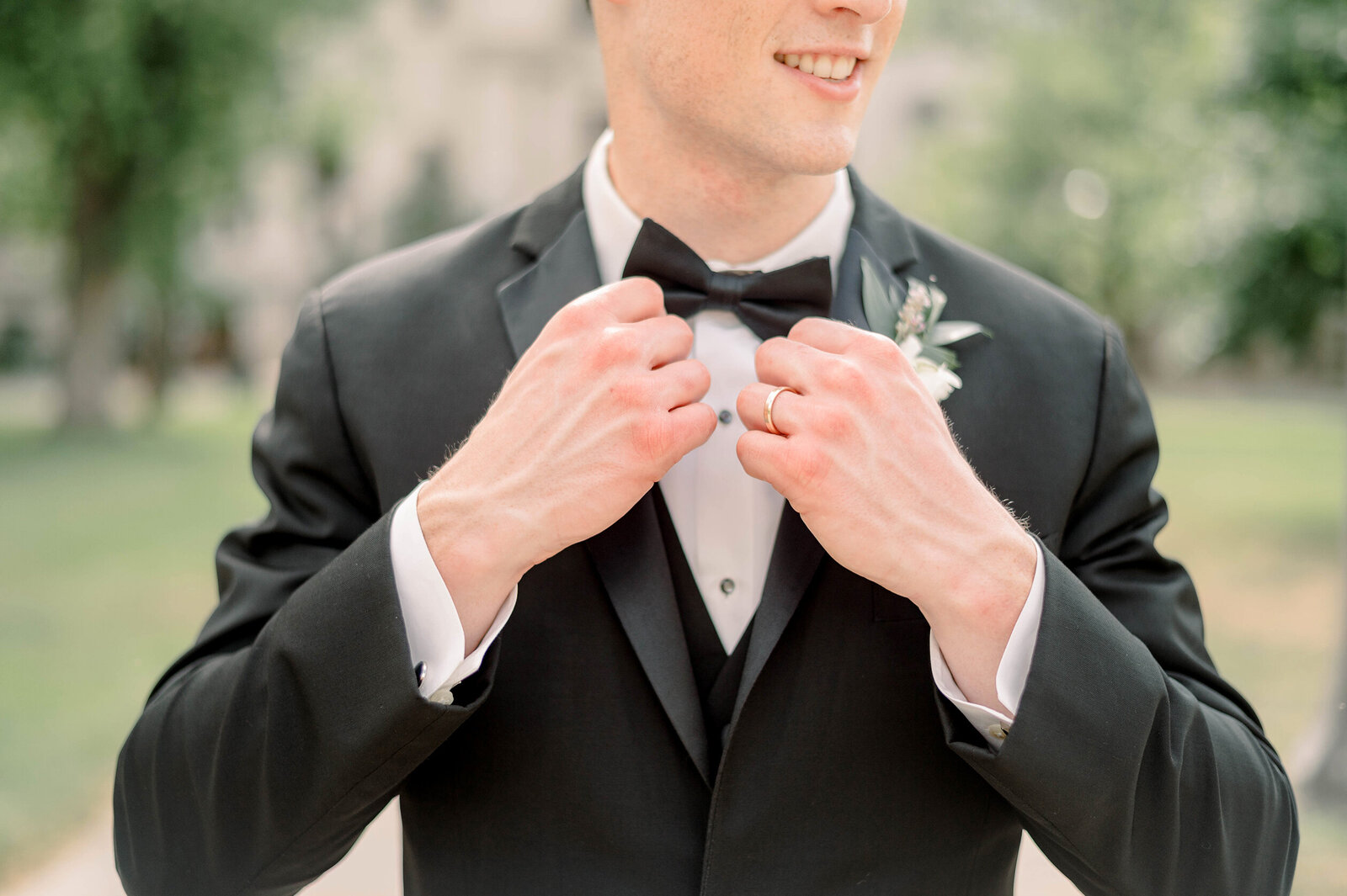 Groom Straightening his bow tie on wedding day