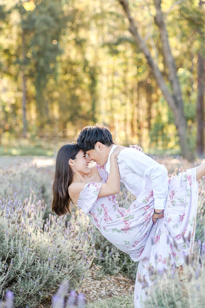 light airy engagement photos of couple dancing in lavender field