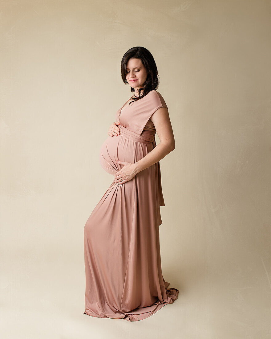 Mother posed holding baby bump, Pregnancy photographers Bettendorf