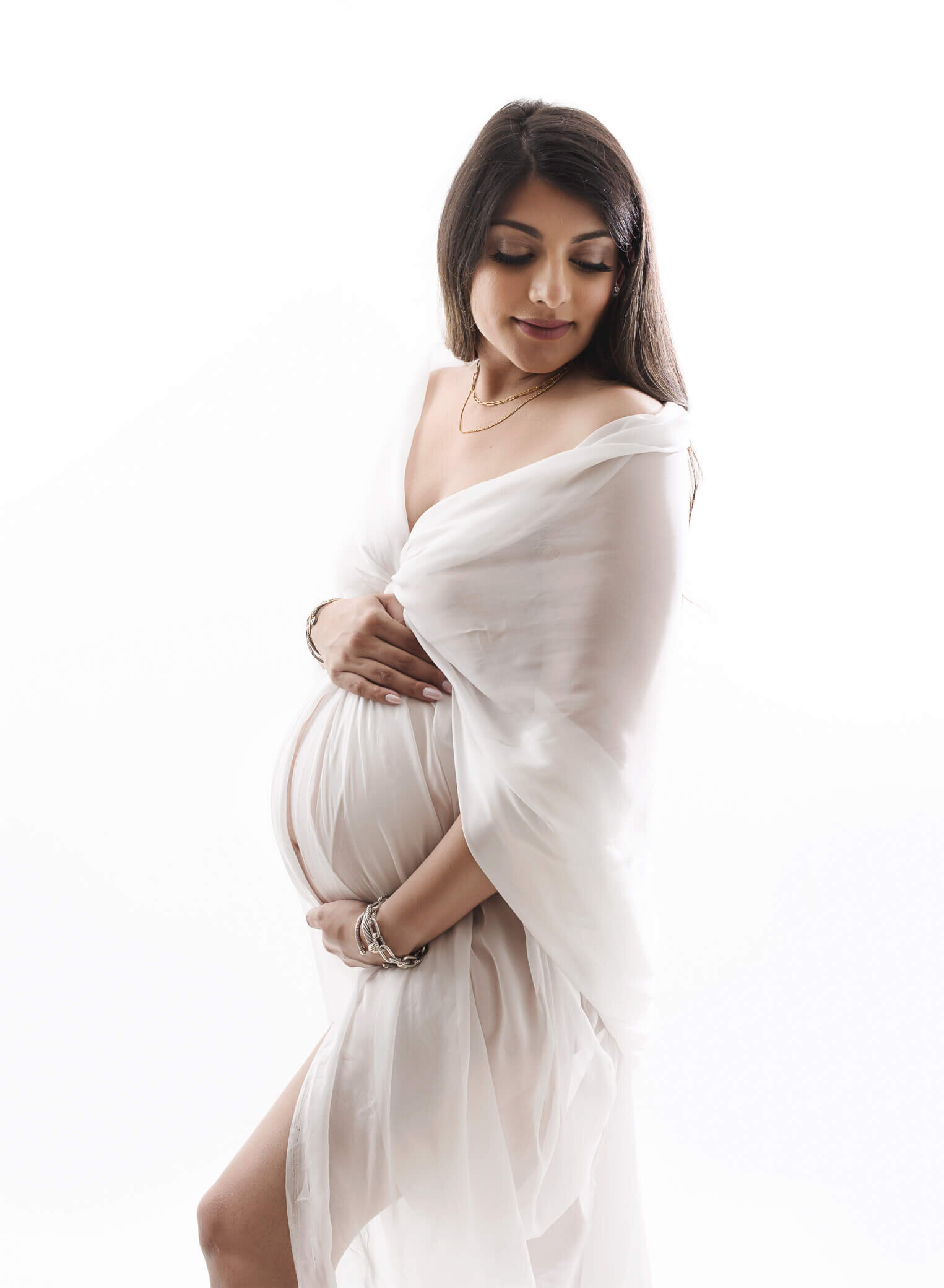 pregnant mom wearing white fabric, back lit
