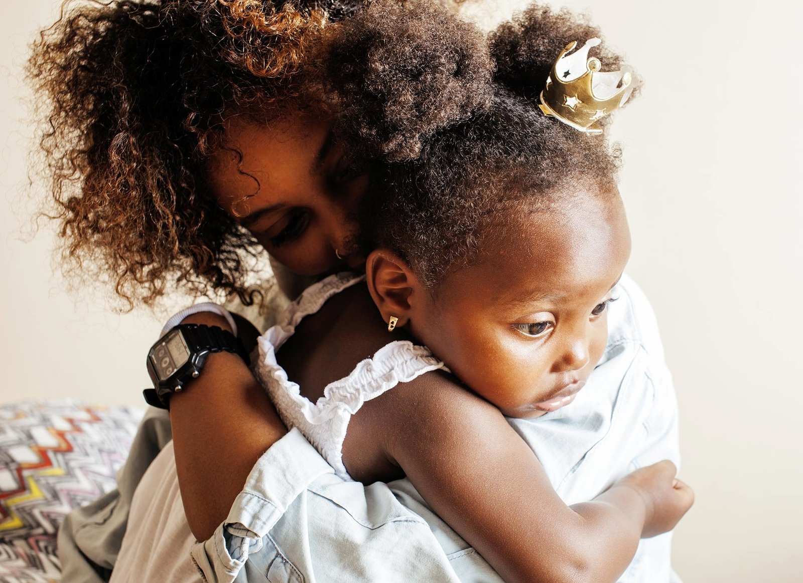 Loving Black mother hugging her toddler warmly, radiating joy and affection in a family moment. Discover more heartwarming stories at Successful Black Parenting Magazine.