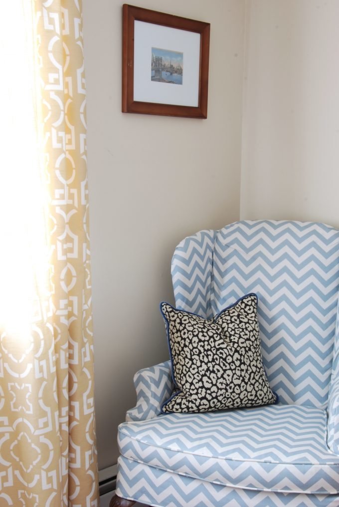A blue and white chevron chair with a leopard throw pillow.