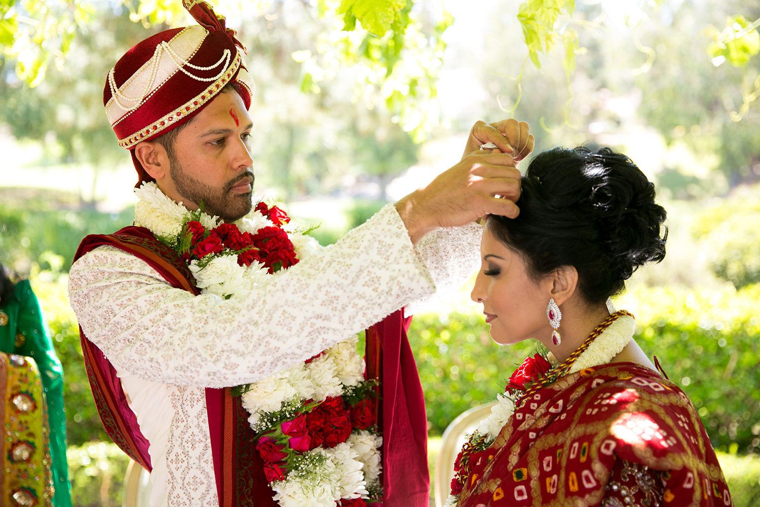 The groom performs māņg sindoor ritual during an Indian Hindu wedding ceremony