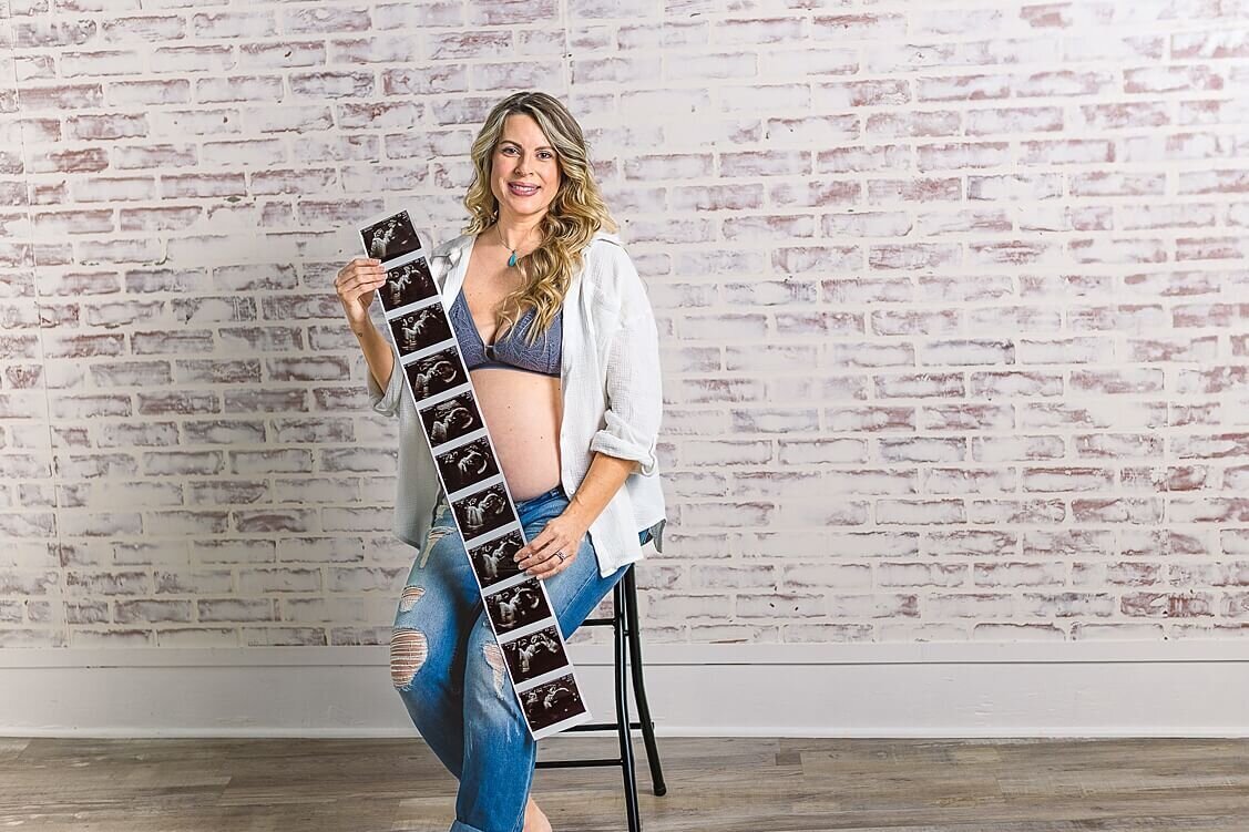 Wexford Maternity Photographer took a picture of this beautiful mama to be sitting on a chair and holding her ultrasound pictures.  