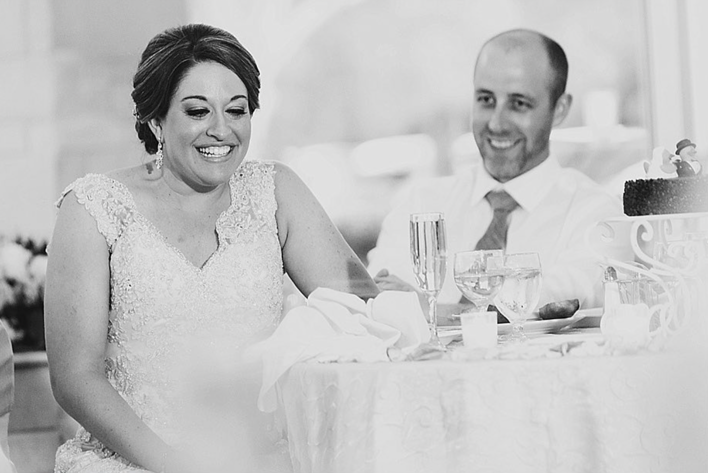 Bride and groom smile at their wedding reception
