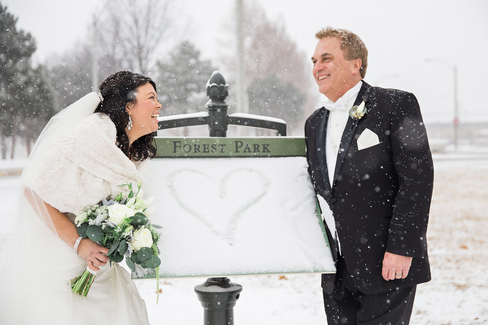Couple having fun at their snowy Forest Park wedding in St Louis