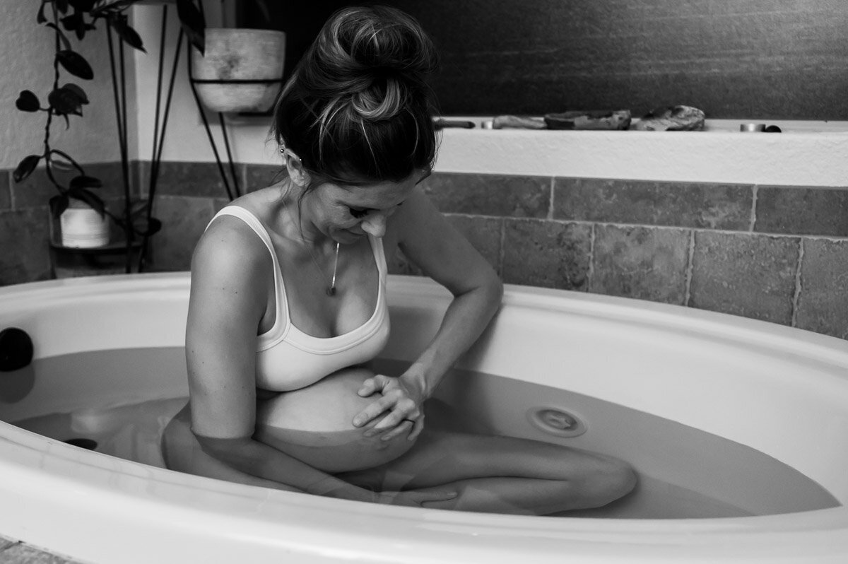 woman smiles between contractions in birth tub