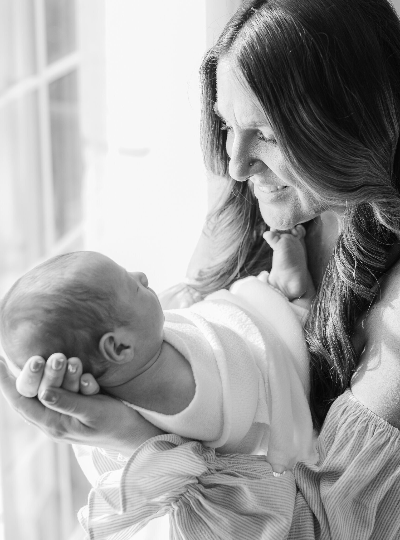 black and white image of mom holding newborn son