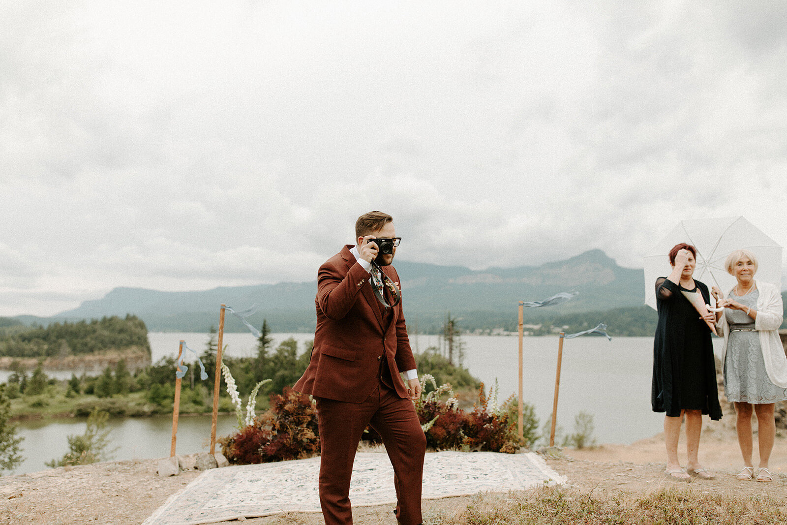 groom taking a photo of his bride walking down the aisle
