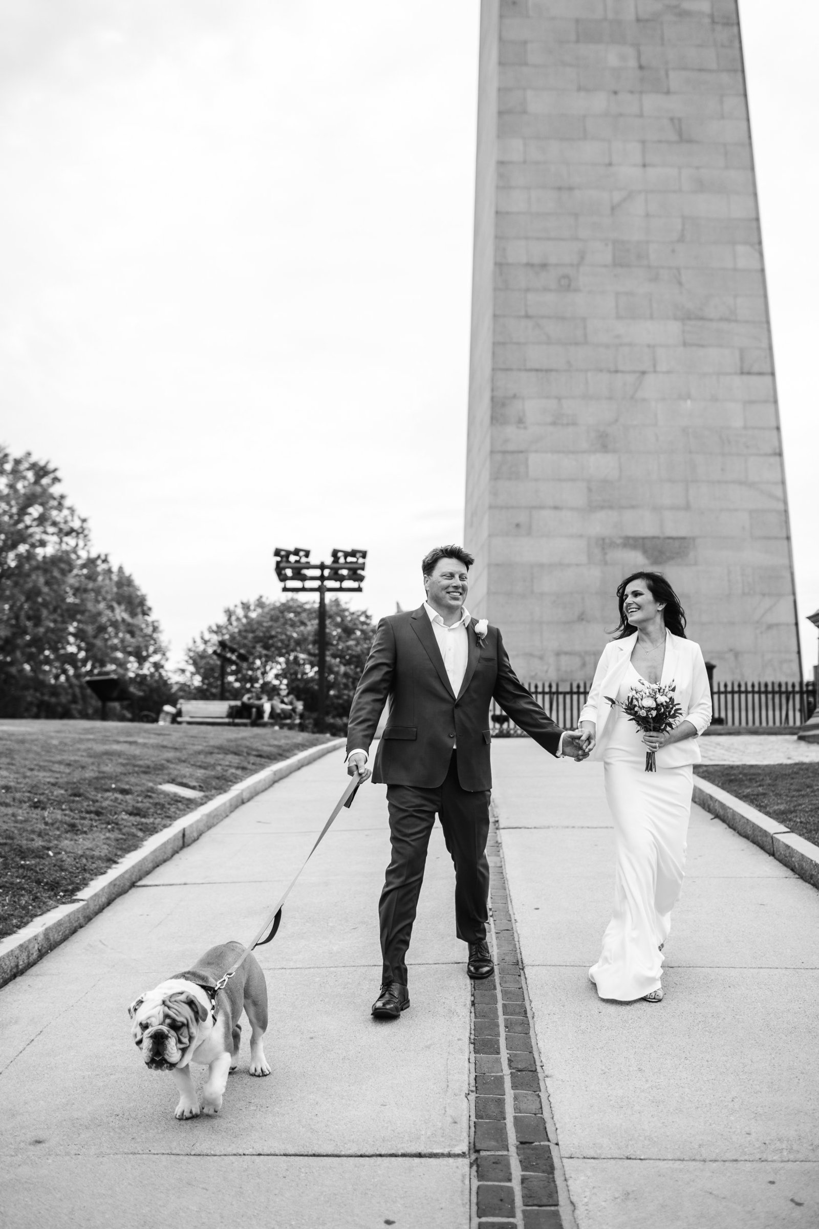 black and white image of a bunker hill elopement couple walking bulldog