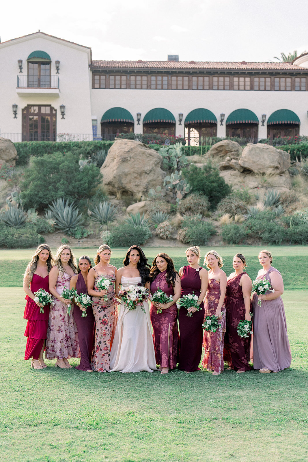 Bridesmaids in floral dresses pose with the bride at Hummingbird Nest Ranch, styled for a romantic Simi Valley wedding.