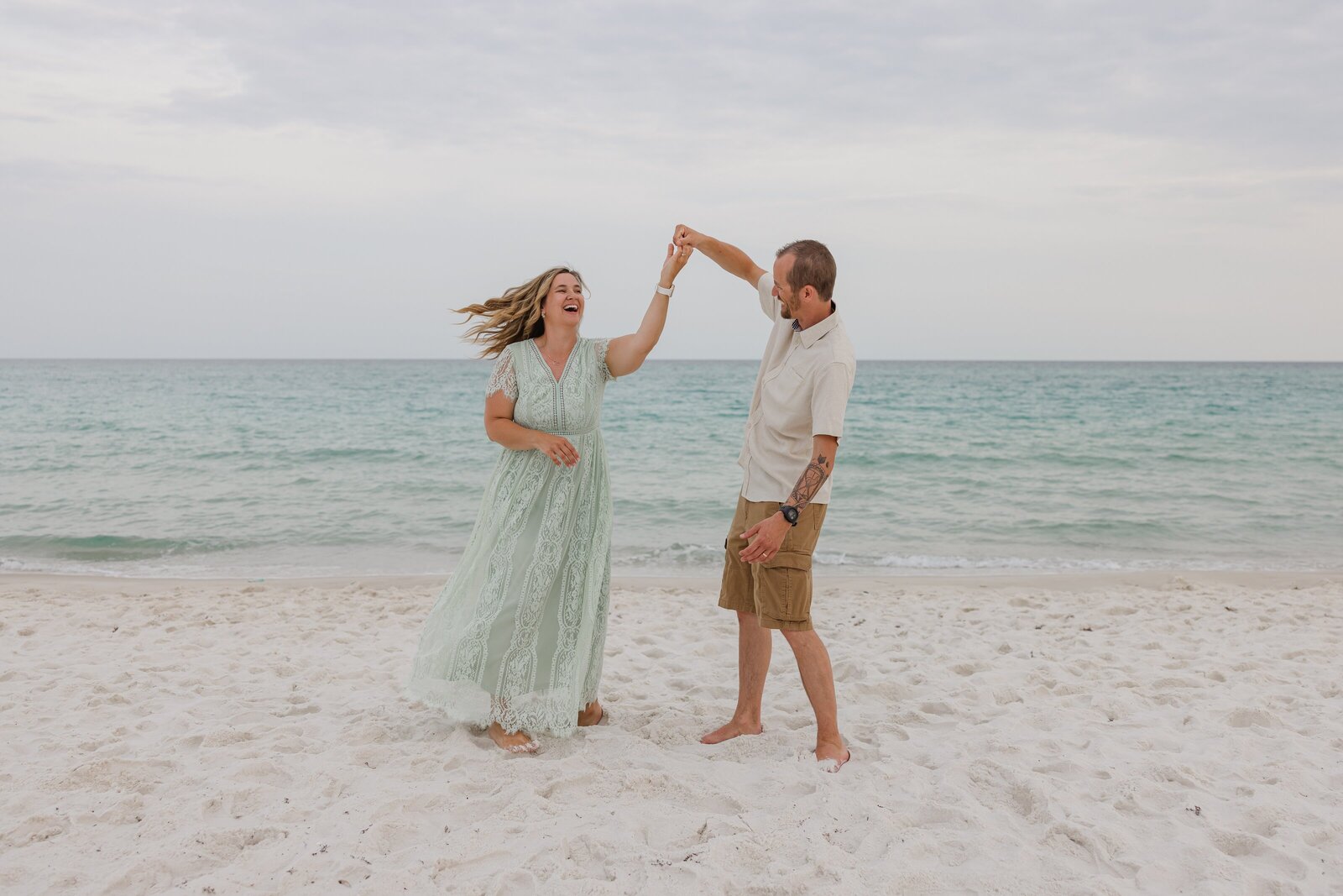Mom and dad dance and laugh during beach photo session near Fort Pickens, Gulf Islands National Seashore