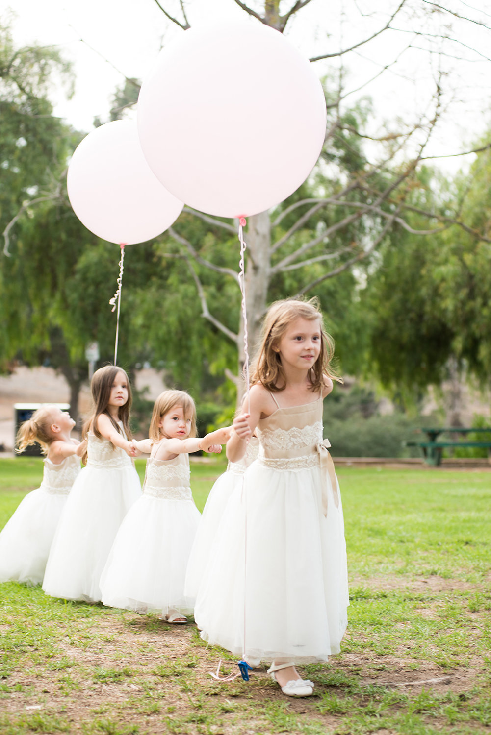 Flower girls make their entrance at an outdoor wedding ceremony