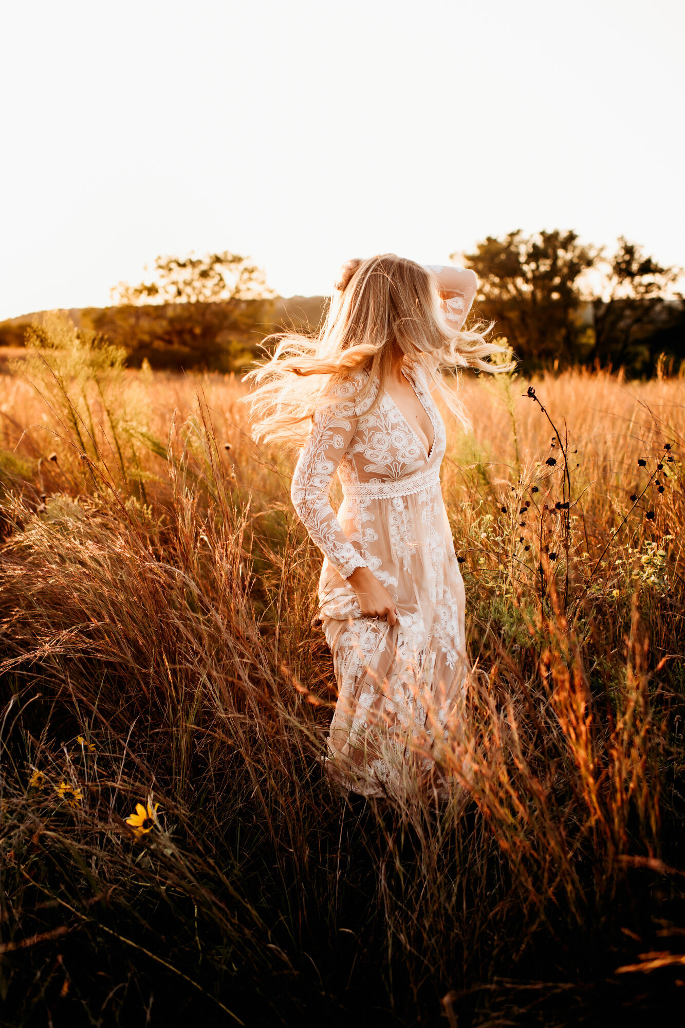 Branding Photographer, a woman in a dress runs through dry meadows at golden hour