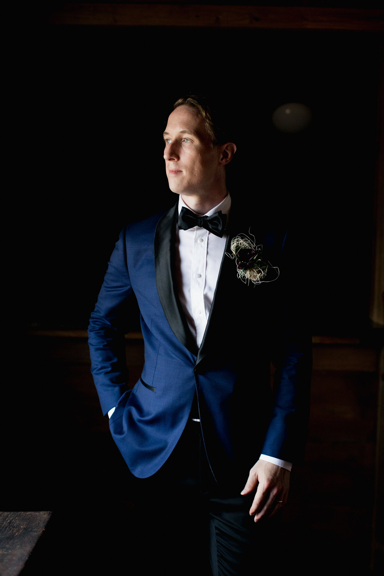 groom with blue suit at window light