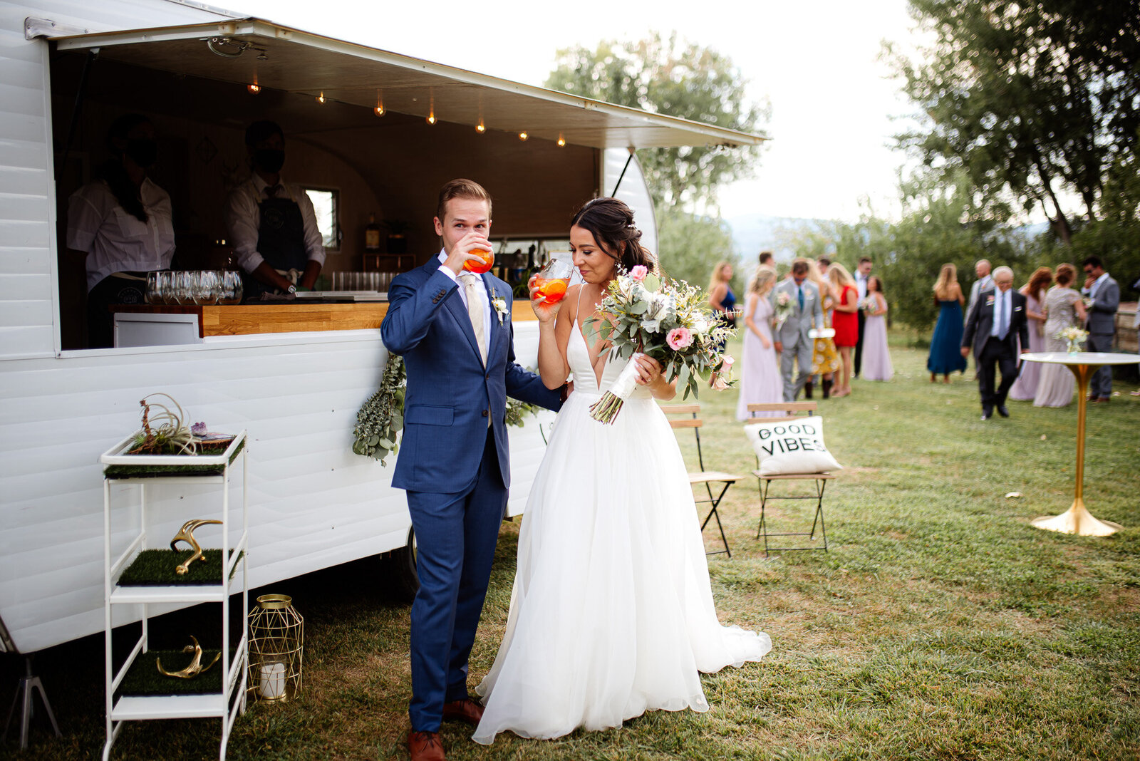 bride and groom get their first drink at their mobile bar in outdoor wedding setting