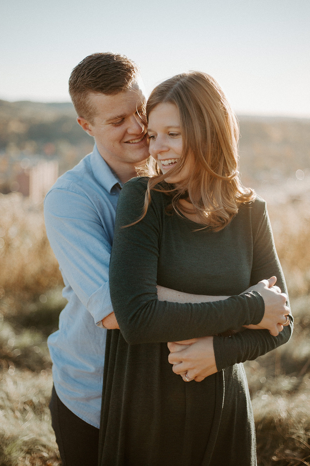 Man hugging his girlfriend form behind during their Minneapolis engagement session