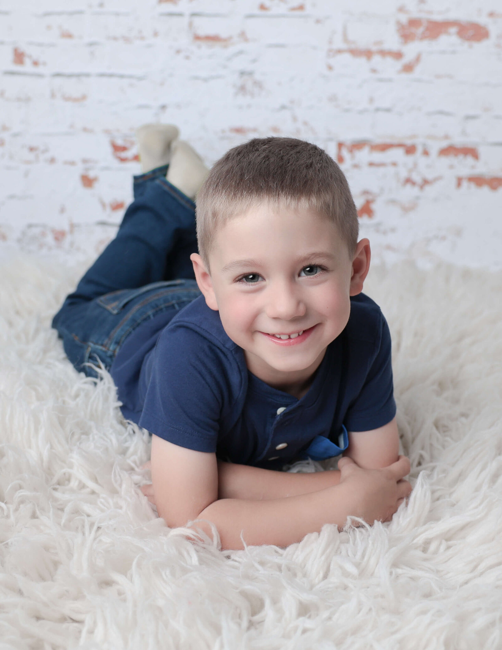 Four year old boy posed on his belly at our studio in Rochester, NY.
