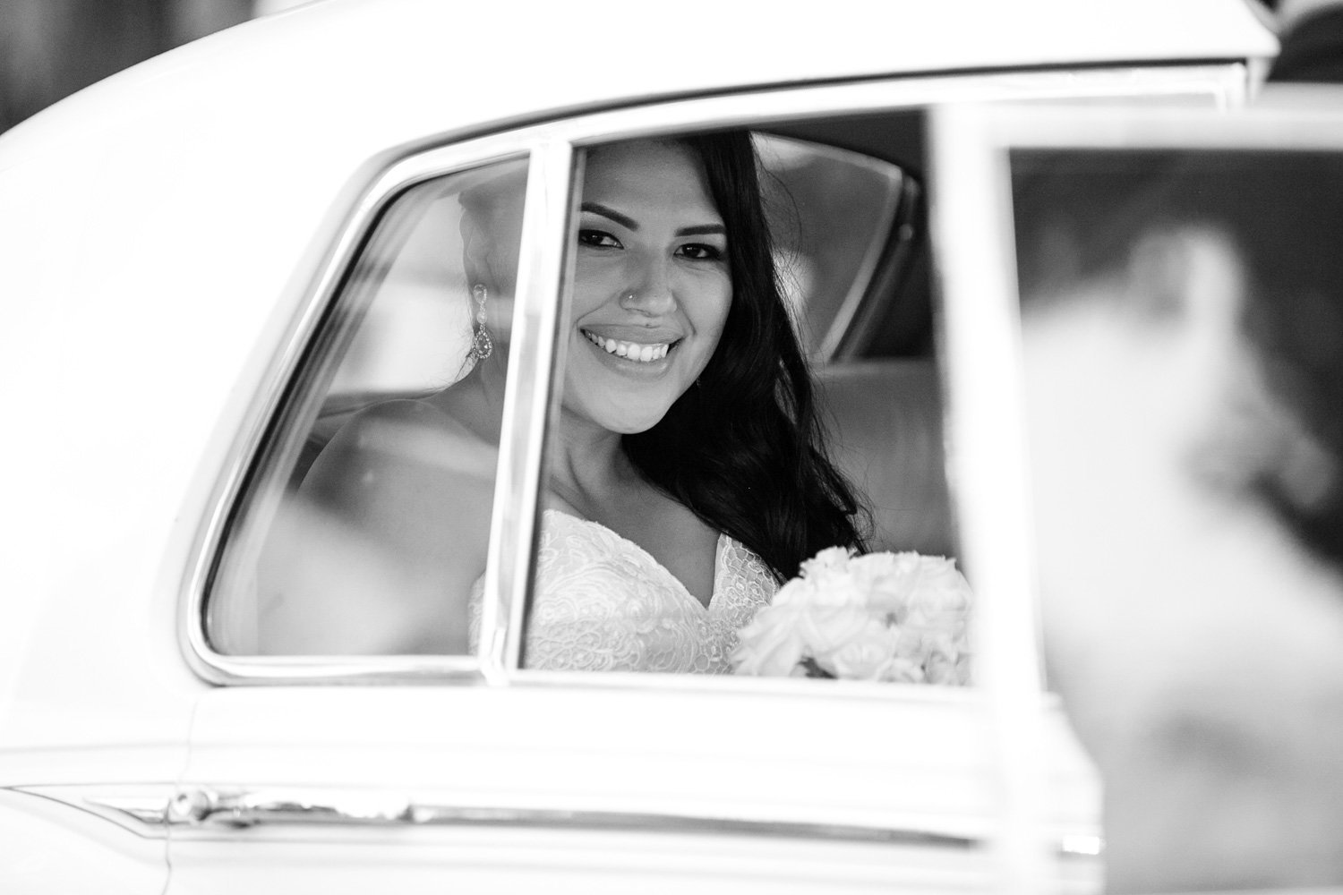 black and white photo of bride in rolls royce at wayfarers chapel