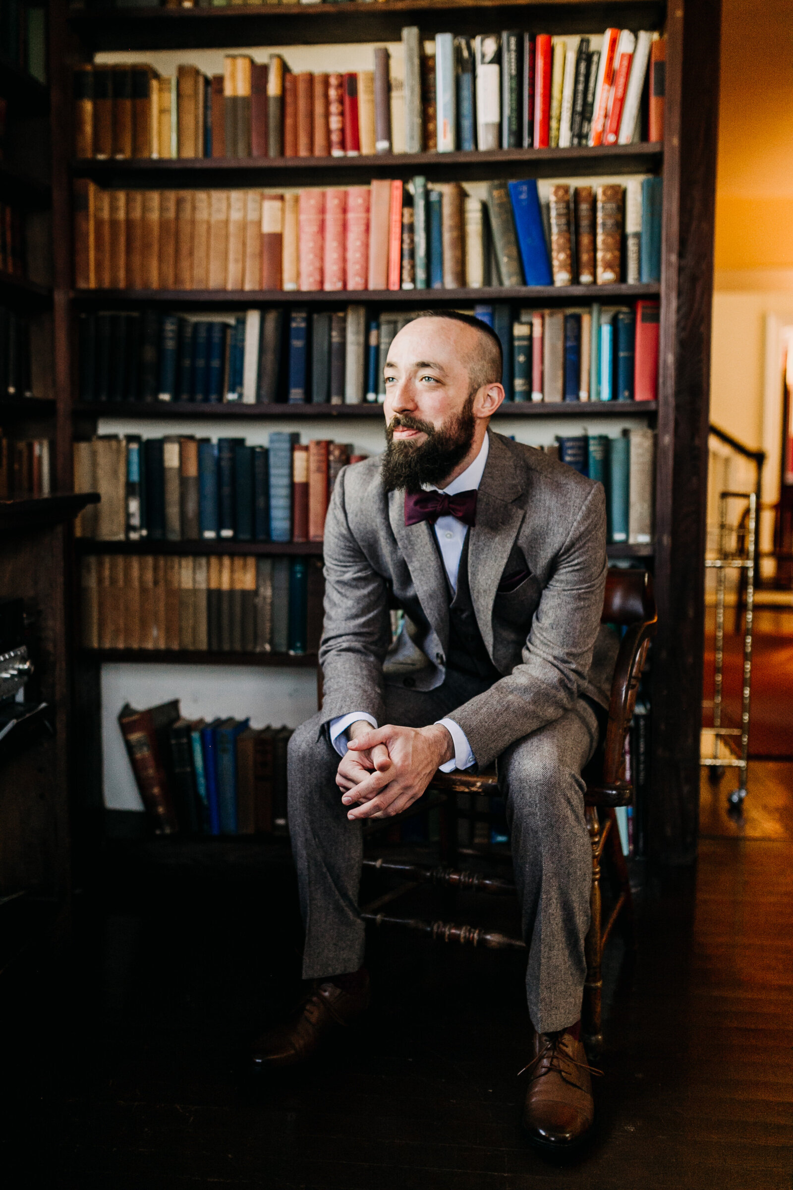 groom with bowtie wool suit in old library