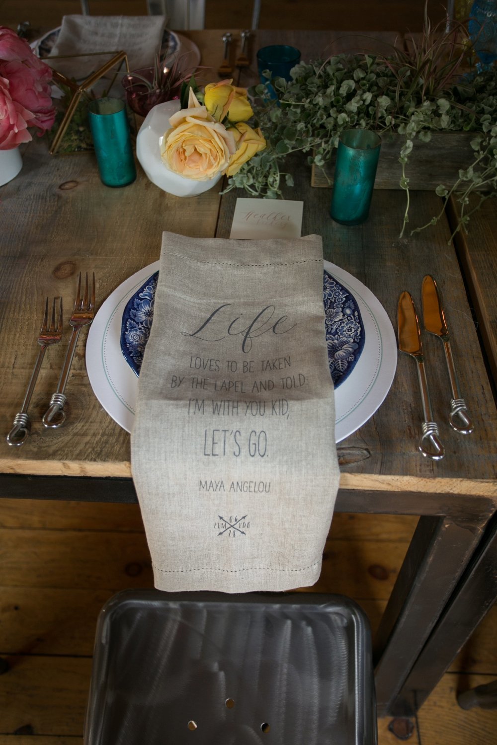 Rustic barn wedding place setting with custom linen napkins at The Barn on Walnut Hill