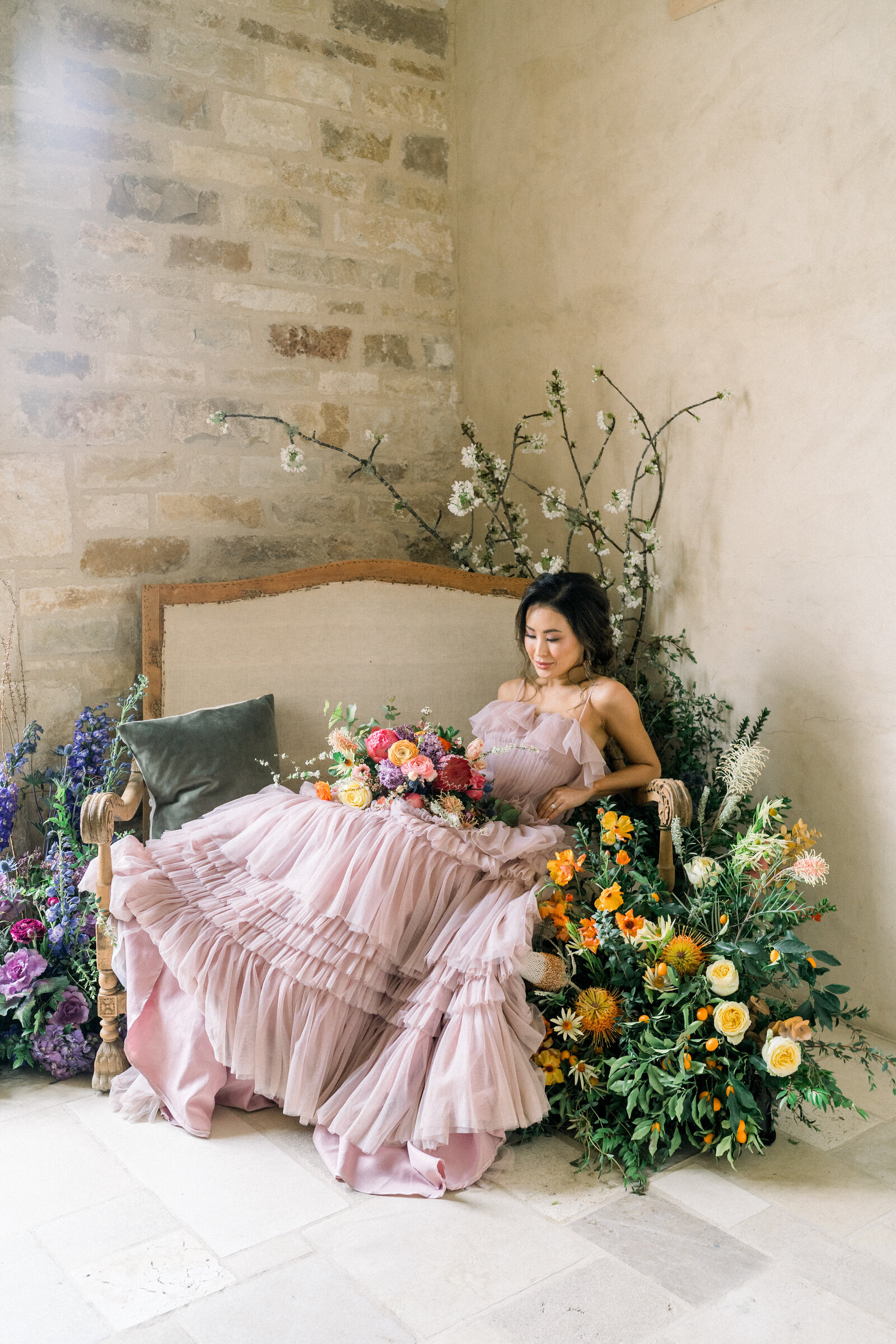 Bride wearing a blush dress among flowers at her Sunstone Winery wedding in Santa Ynez, CA