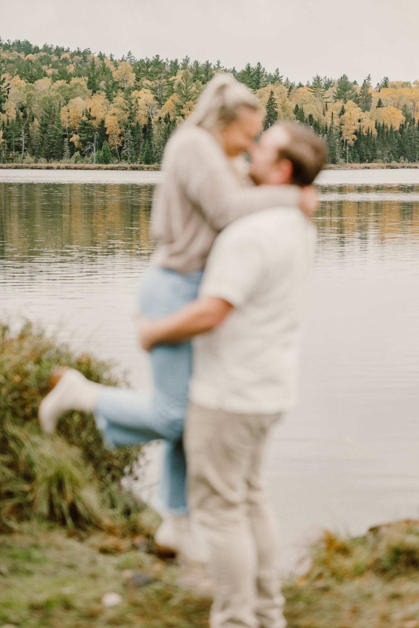 Man lift woman up during Fall engagement photos on Minnesota's North Shore
