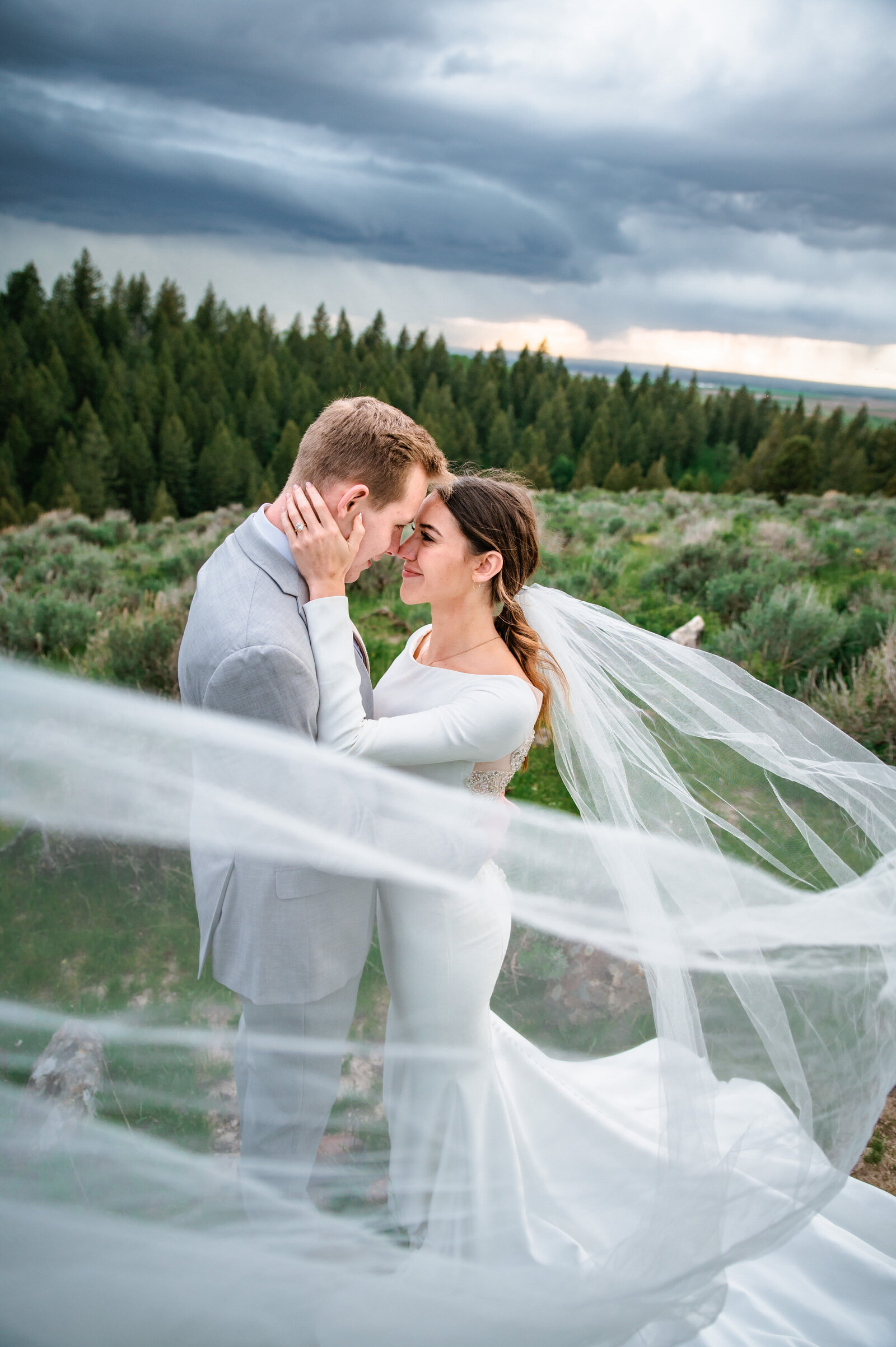 Jackson hole photographers capture bride touching groom's face after Grand Teton wedding