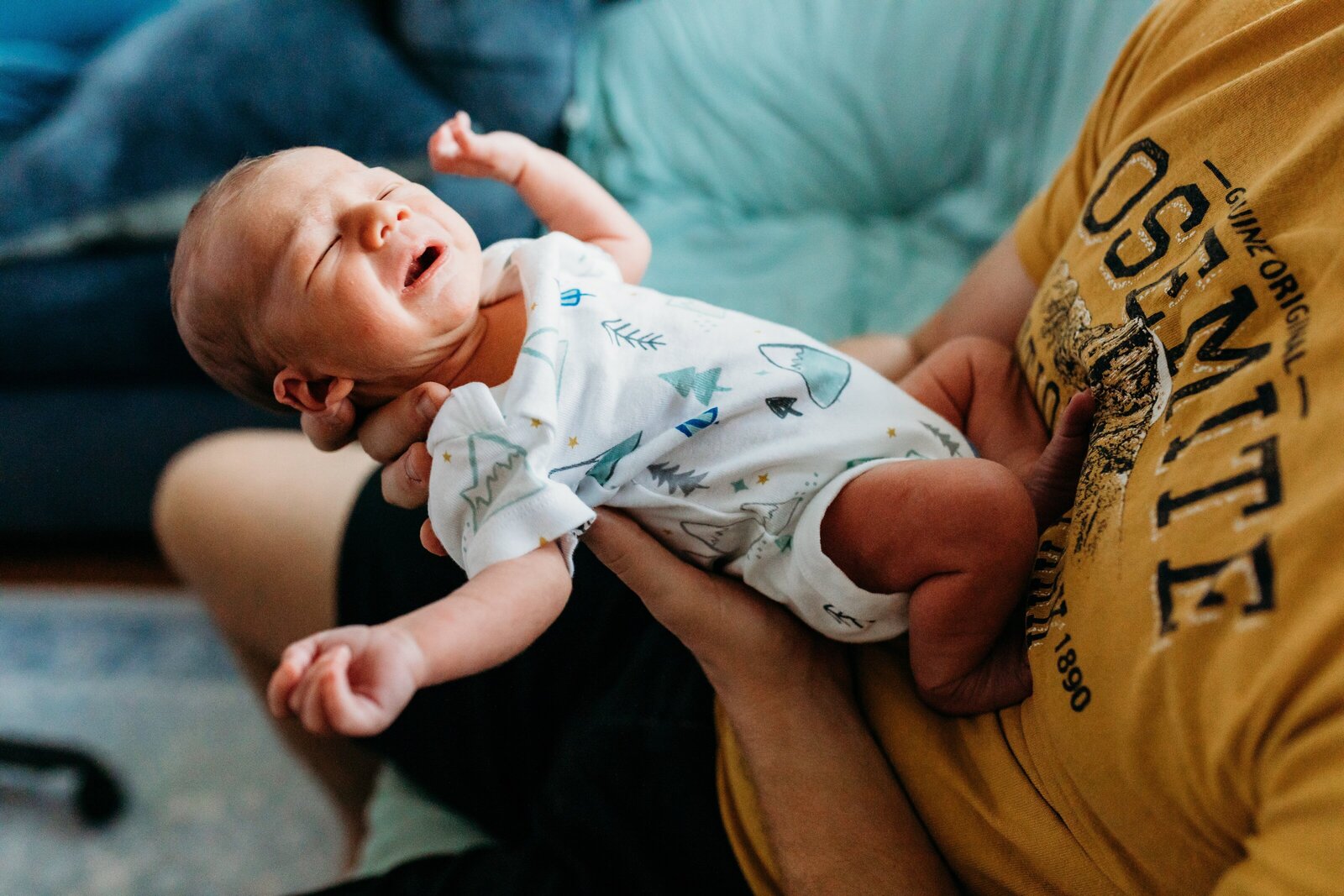 newborn baby in father's arms