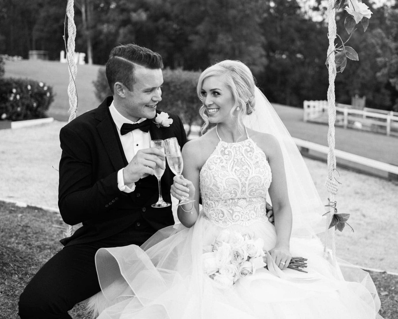Bride and groom sitting on a swing at Austinvilla Estate
